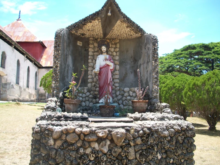 a statue sitting on top of a pile of rocks