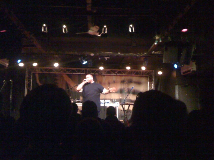 a man standing on top of a stage in front of a crowd