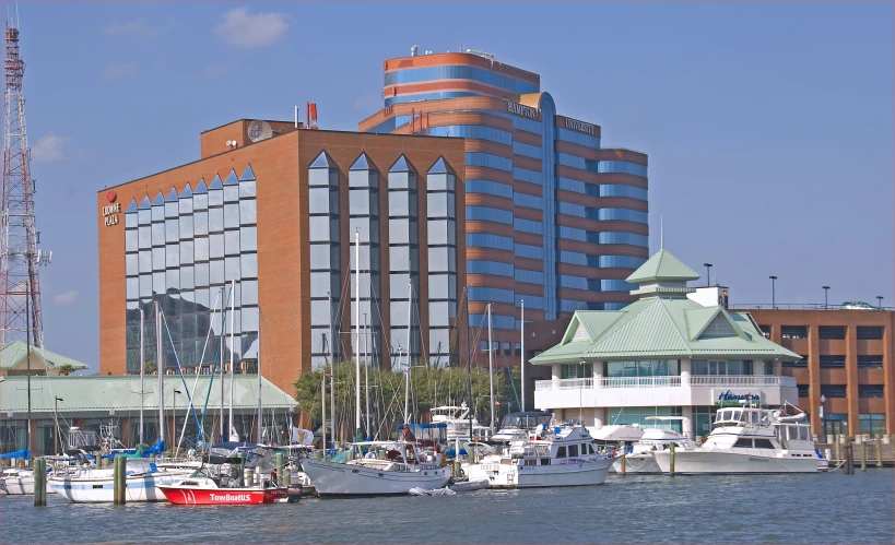 many boats floating on the water in front of a large building