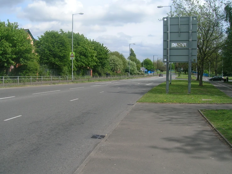 there is a road with a fenced in side walk on the side