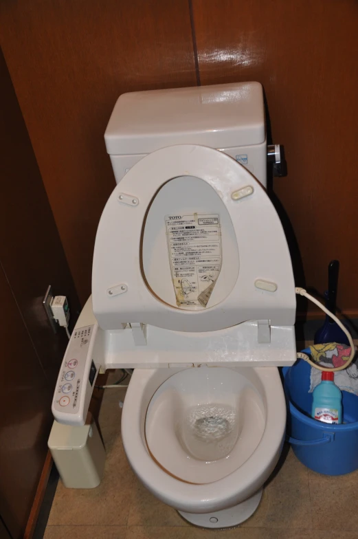 a toilet with its lid up inside a stall