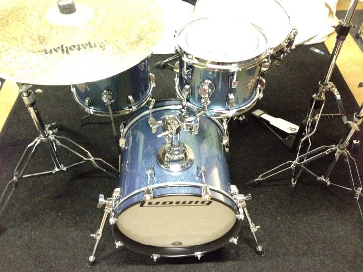 a blue and white drum kit sits on a mat