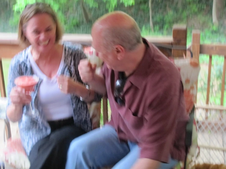 a man feeding soing to an older lady