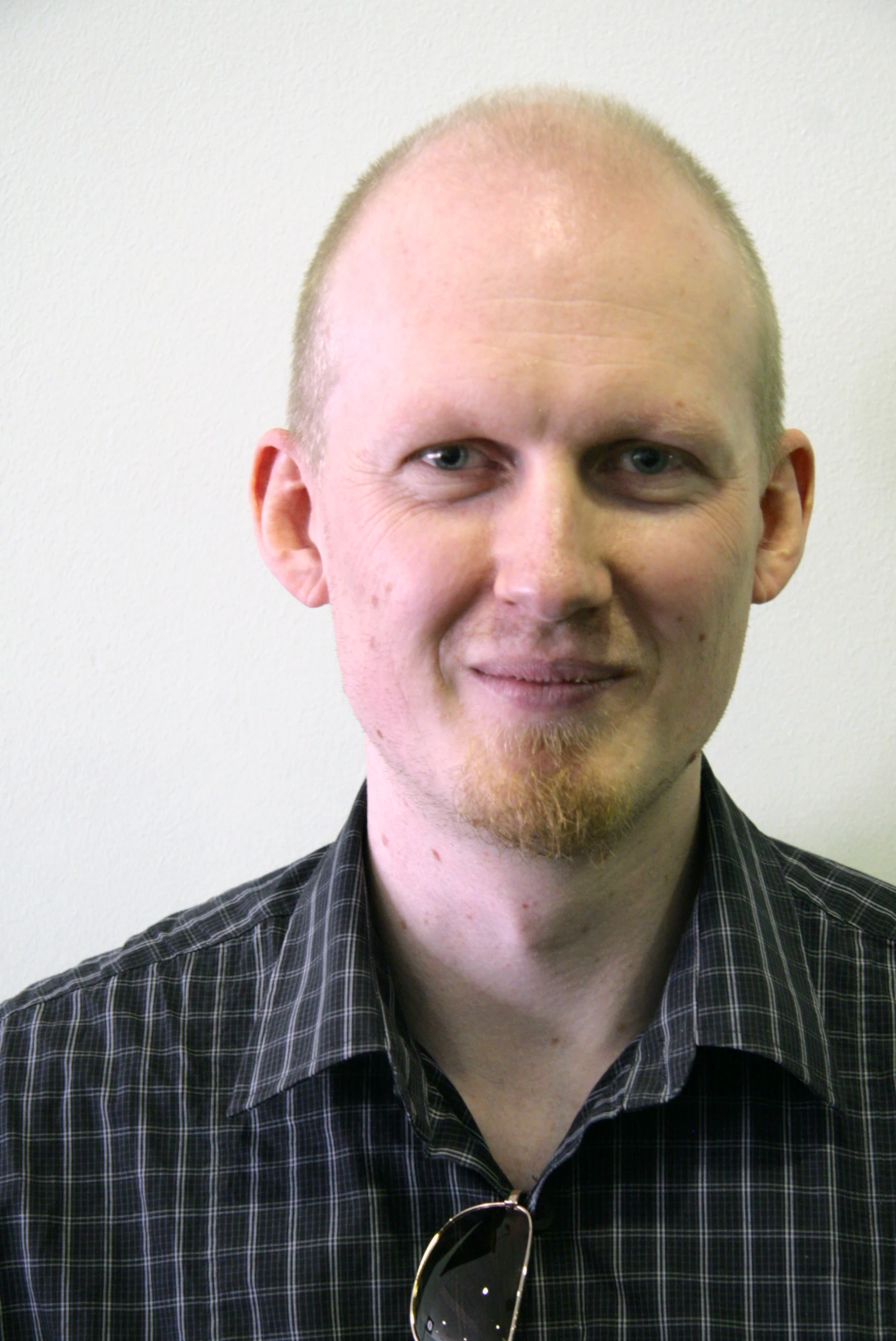 a bald headed man wearing a tie and plaid shirt