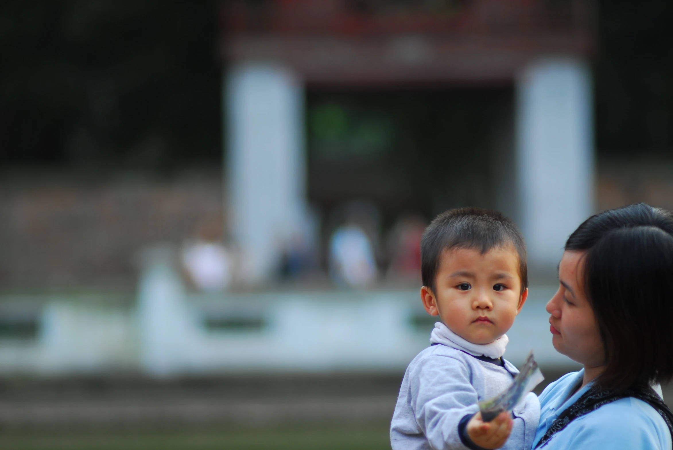 a little boy being held up by his mother