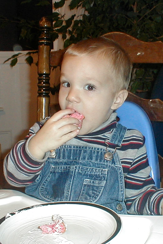 a small child sitting at a table in front of a cake