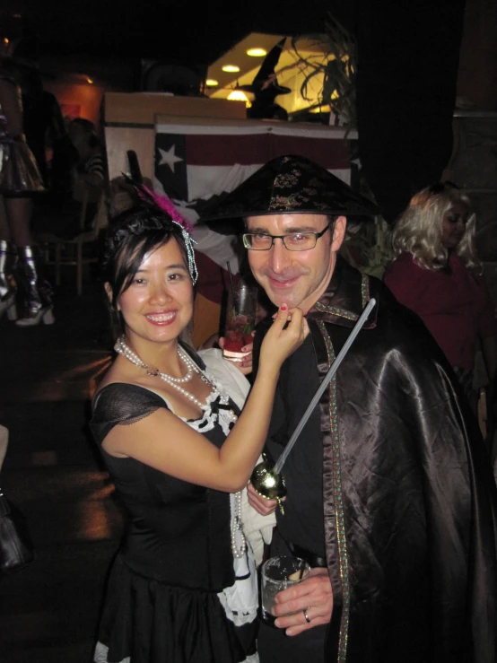 a man wearing a pirate costume is holding a woman