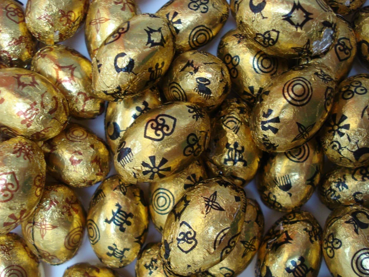 a pile of gold foiled eggs sitting on top of a table