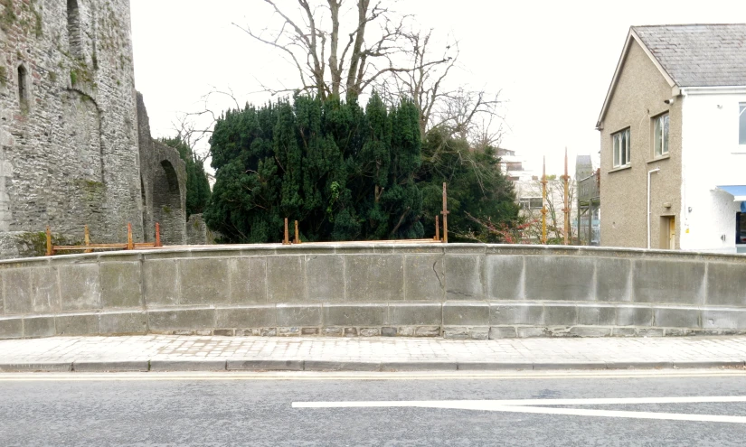 a small brick and concrete structure beside a city road