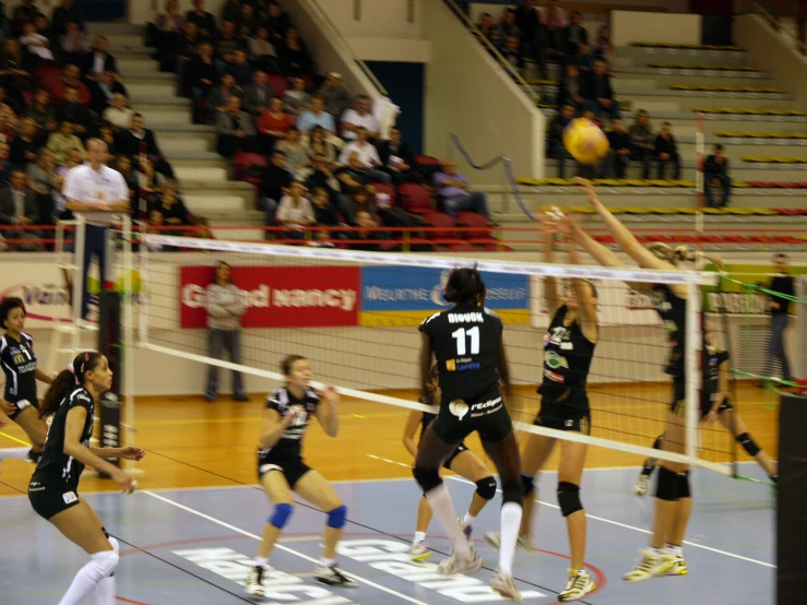 two women are playing volleyball while a large crowd watches