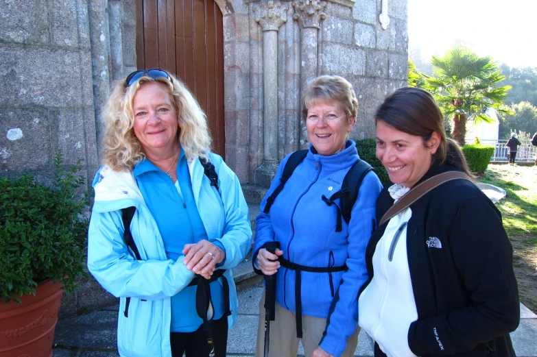 three women standing on steps near a building