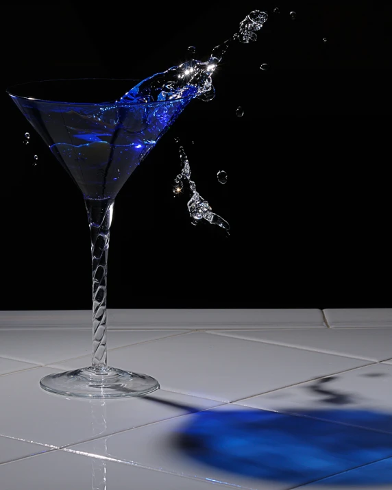 a blue glass with water pouring into it