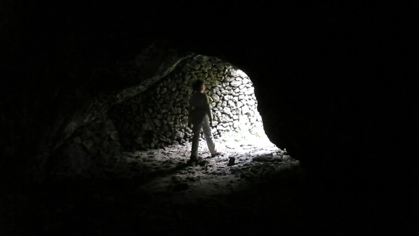 a person that is standing by a very large rock