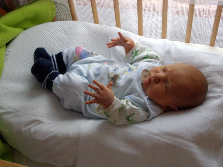 a newborn baby laying on top of a white pillow