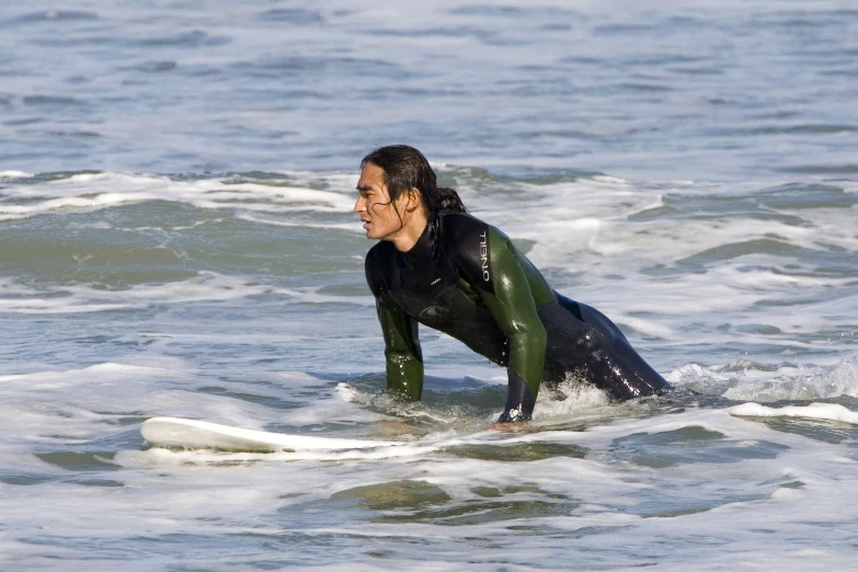 a man on a surfboard is looking at the ground