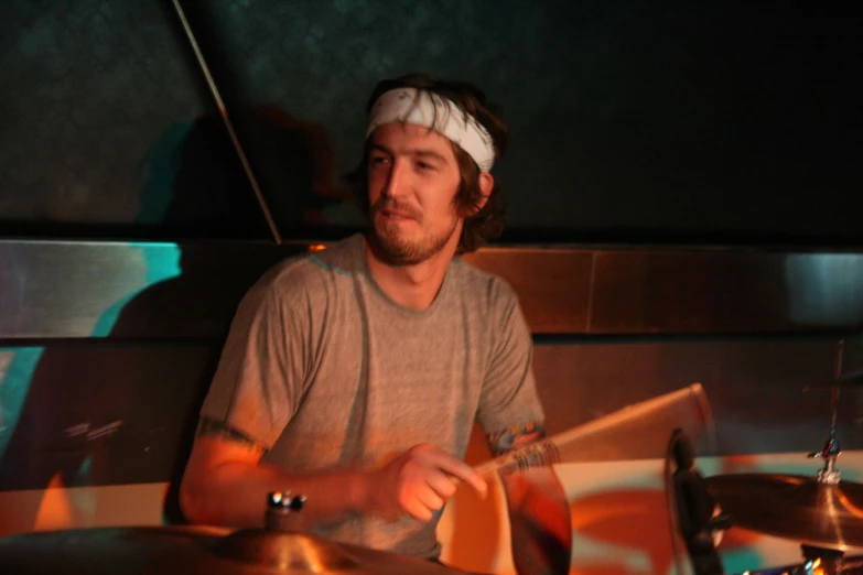 a man with a bandage around his head playing drums