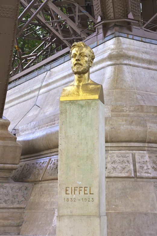 a close up of a yellow statue near the bridge