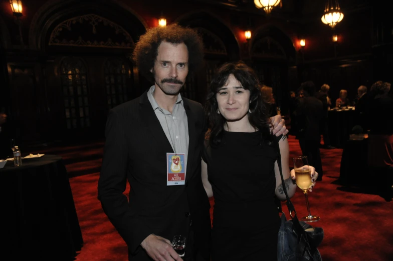 a woman and man pose together at an event