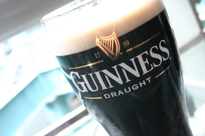 a glass of dark ale sitting on top of a counter