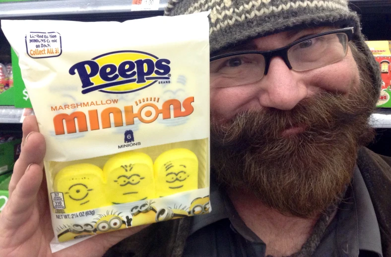 a man with a beard holding up a package of peeps