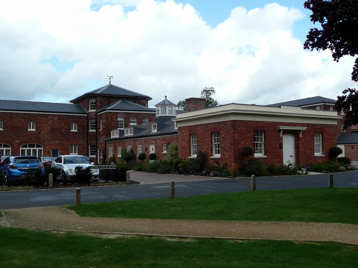 a big brown brick building sitting in a grassy field