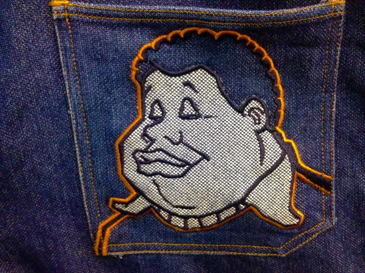 a cartoon avatar is seen on a patch in the back pocket of someones jeans