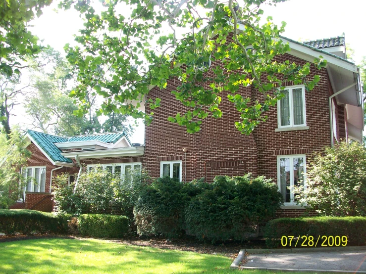 a red brick house with white windows on the top and two floors