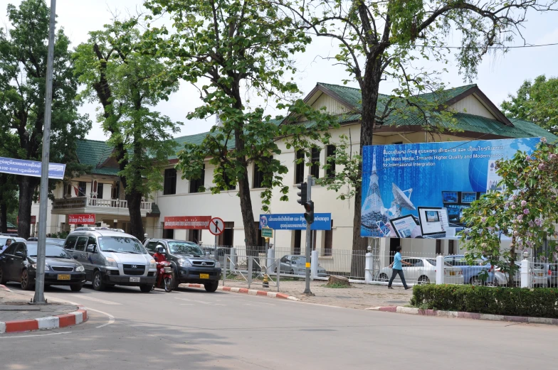 cars in front of an old building with blue banners