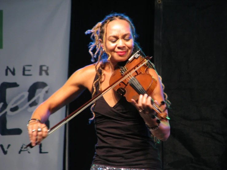 a woman with dreadlocks playing a violin