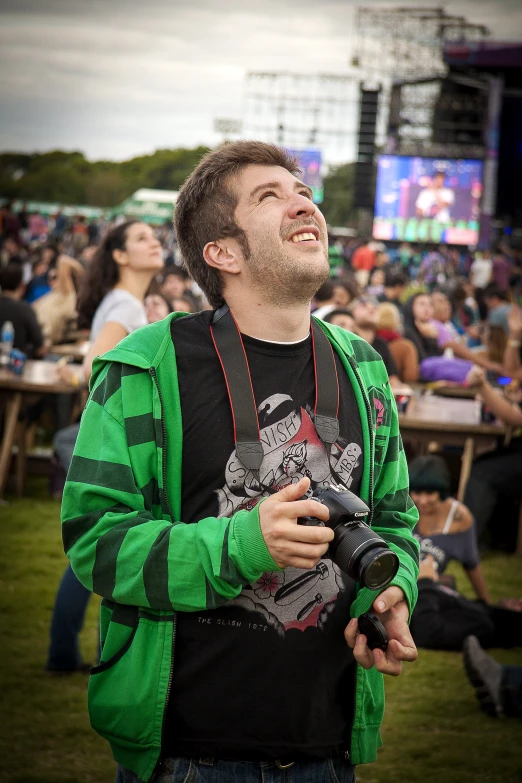 a man standing in front of an outdoor audience at a music festival
