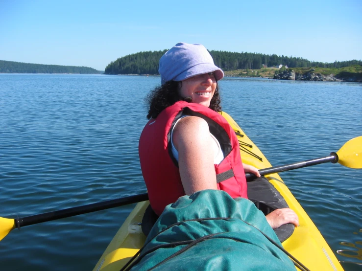 a woman is paddle boating on a clear blue river