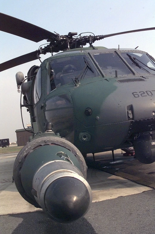 a large helicopter sits on the ground in a parking lot