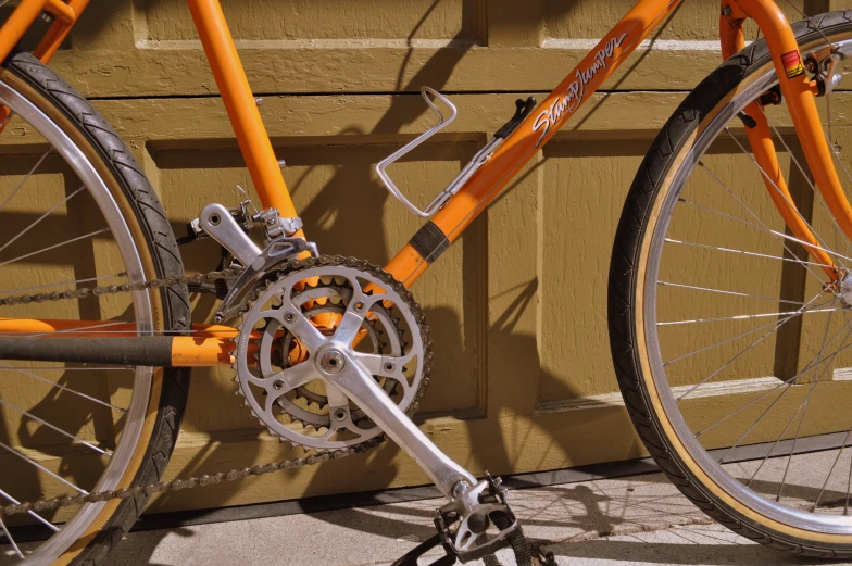 a bicycle sits against a wooden fence