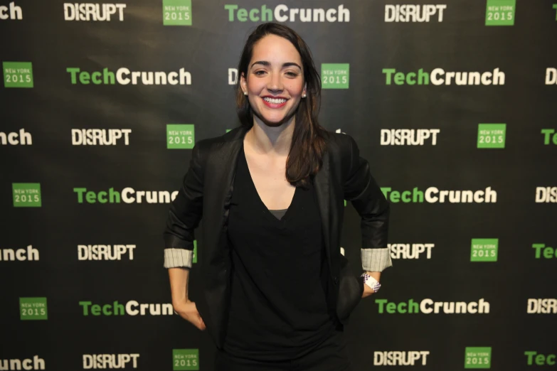 a woman standing in front of a backdrop with techcrunch logo