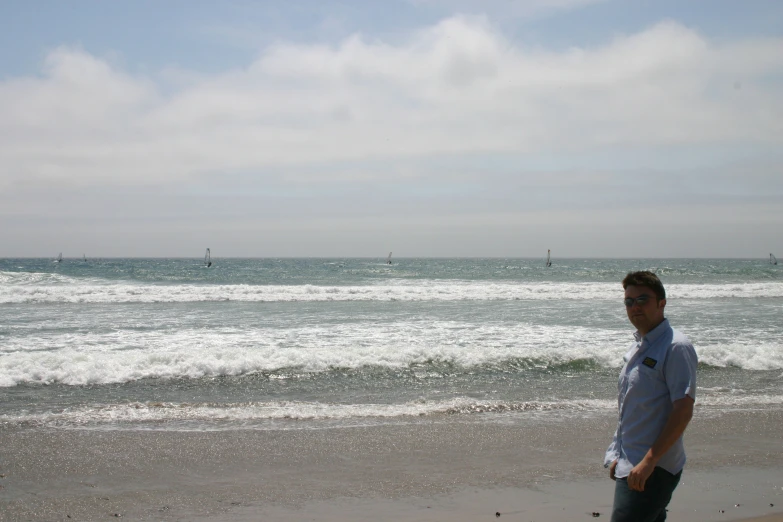 there is a man on the beach with some surfboards