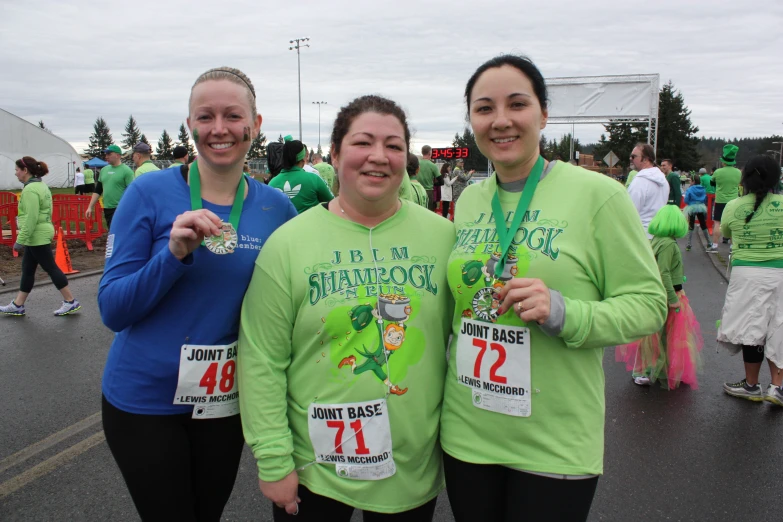 three female runners with medals on their laps in the race