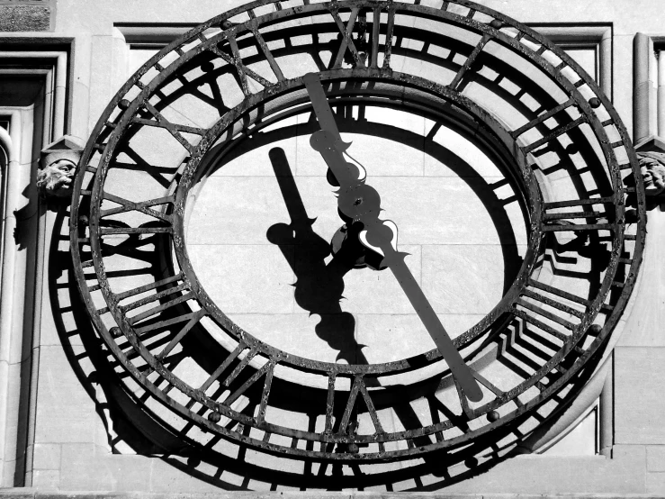 a person's shadow can be seen at the base of a clock