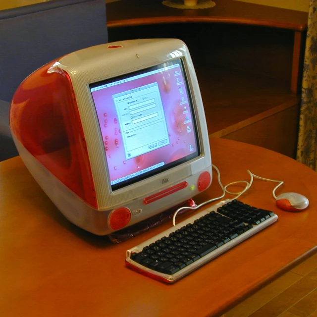 an apple computer sitting on top of a wooden desk