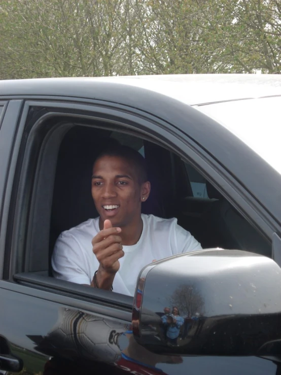 a man is smiling in the drivers seat of a truck