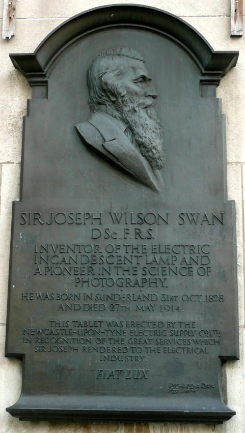 the memorial plaque is next to a plaque with an image of a man