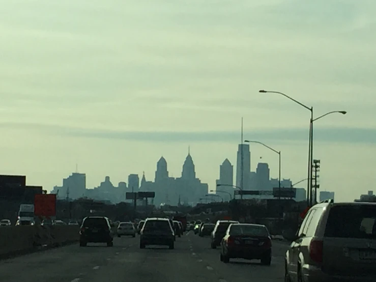 cars are traveling down an interstate heading toward a city