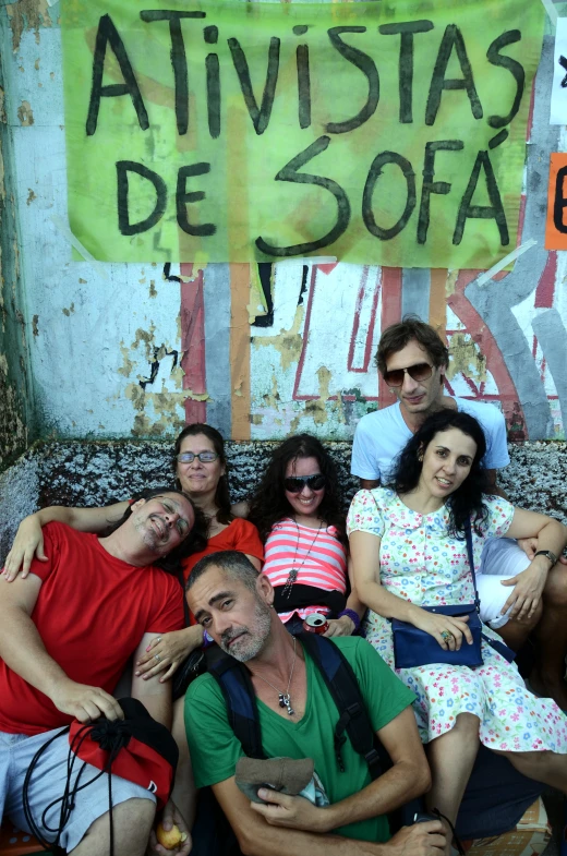 a group of people that are sitting down on a stone ledge