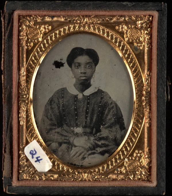 an old fashioned black woman wearing a white blouse