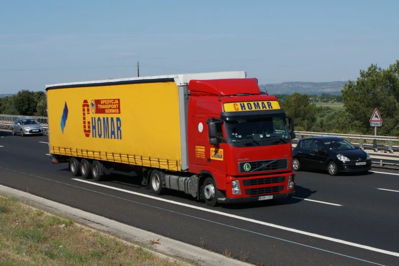 a yellow and red semi truck driving down the road