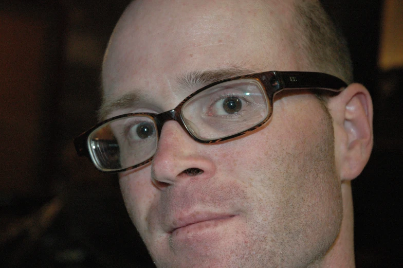 a man wearing eye glasses staring intently at soing