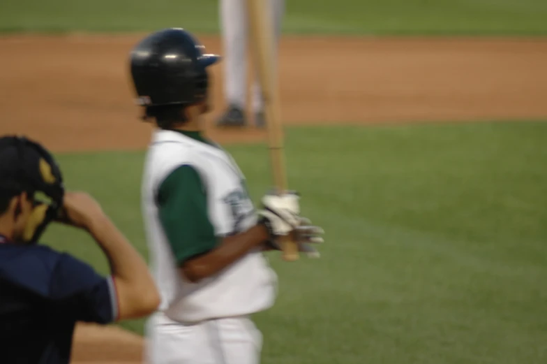 a  holding up a baseball bat on top of a field