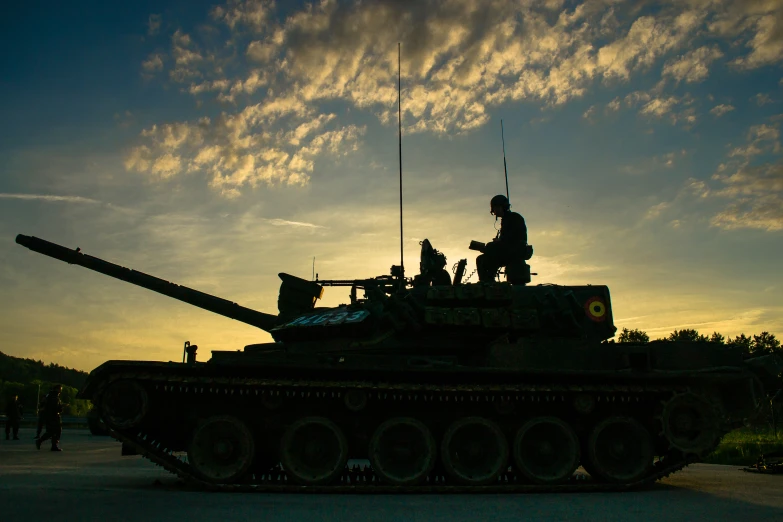 people sitting on top of an army tank