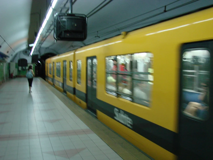 people walking past a train pulled into the station