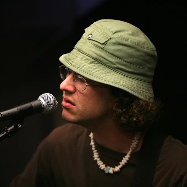 a man with a hat and a microphone