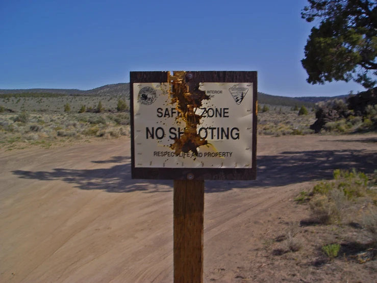 a no stopping sign next to an open dirt road